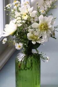 Dahlia Blanc Y Verde and Michaelmas daisies in a green bottle vase